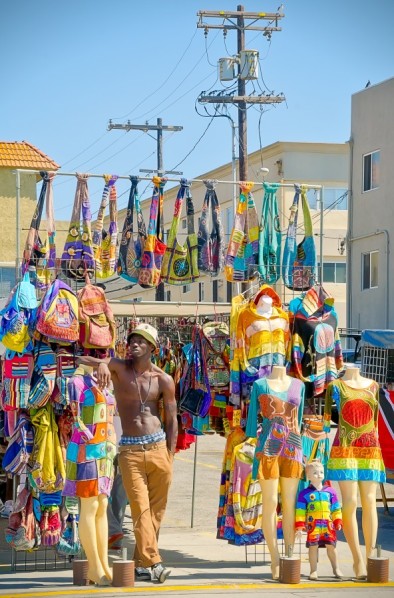 an image of a young man selling apparel on the venice boardwalk.