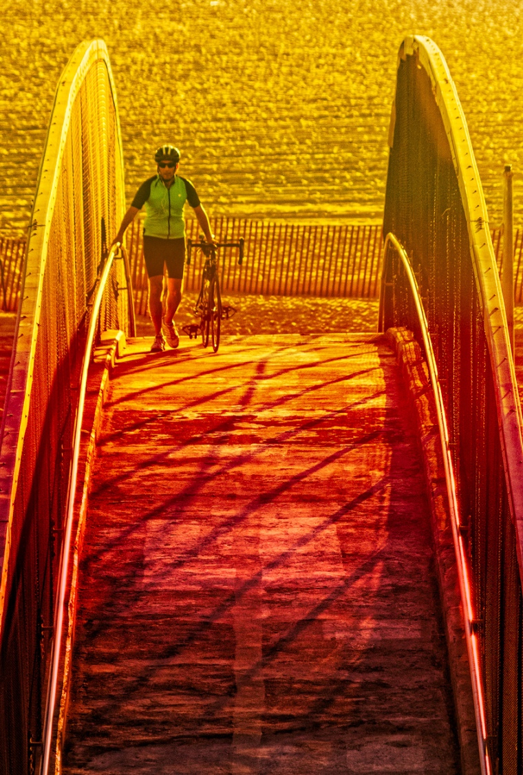 a bicyclist crosses the overpass in Santa Monica